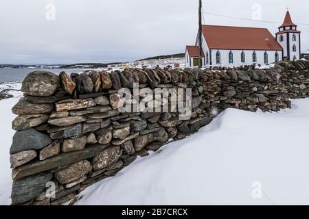 All Saints Anglican Church behind a dry stone wall art installation in English Harbour, Newfoundland, Canada [Stone wall created by an artist; no copy Stock Photo