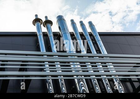 A lot of metal pipes stick out of a large building Stock Photo