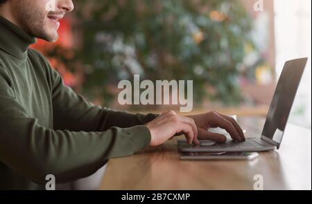 Cropped of male freelancer typing on laptop at cafe Stock Photo