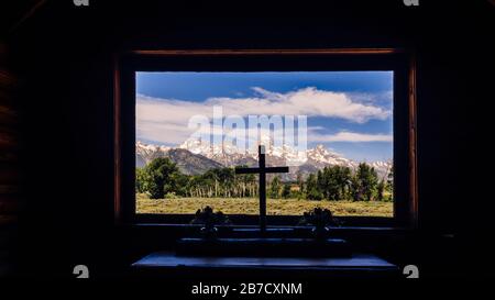 Cathedral peaks panoramic view through chapel window of St John's episcopal chapel of transfiguration church Grand Teton park Moose Wyoming USA Stock Photo