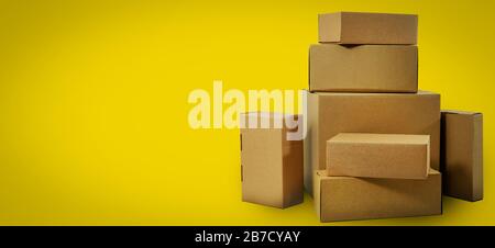 shipping and delivery - blank cardboard boxes on yellow background with copy space Stock Photo