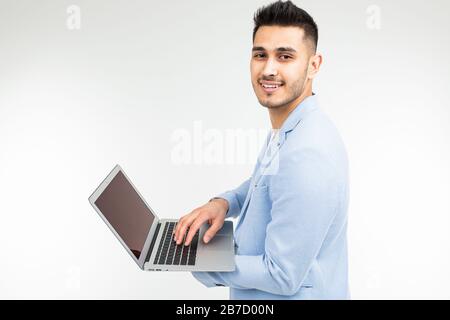 stylish office worker man working on laptop on a white studio background Stock Photo