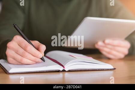 Man hands taking notes and holding digital tablet Stock Photo