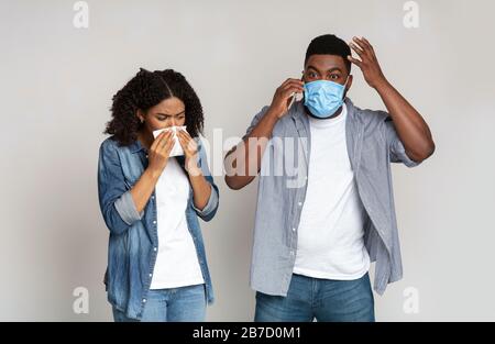 Concerned Man In Medical Mask Calling To Doctor Because Of His Sick Wife Stock Photo