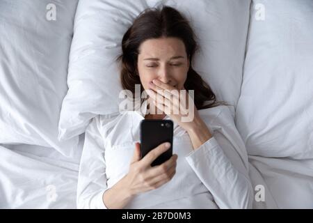 Frustrated young brunette woman crying reading message with bad news. Stock Photo