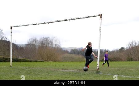 Leighton Jacobs (left) and Riley Hoos play football on a pitch in Ty Mawr Country park, Llangollen, North Wales. Stock Photo