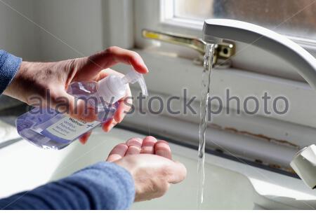 Washing hands regularly at the sink with antibacterial hand wash and running hot water due to the coronavirus covid-19 epidemic pandemic Stock Photo