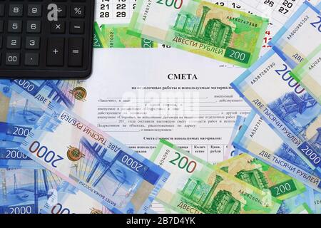 The form of the document with the Russian text Estimates for finishing works and the materials used. Russian money and calculator on the table. The ca Stock Photo