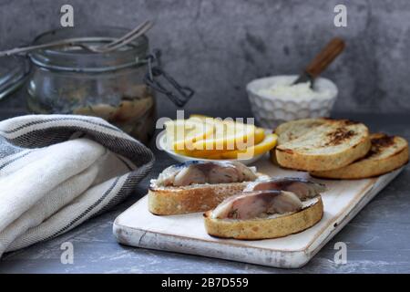 Sandwiches with cottage cheese and gravlax from mackerel, served with lemon. Stock Photo