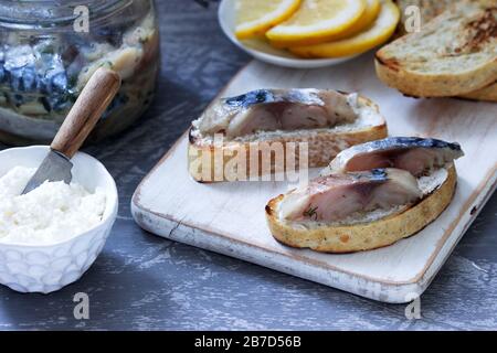 Sandwiches with cottage cheese and gravlax from mackerel, served with lemon. Stock Photo