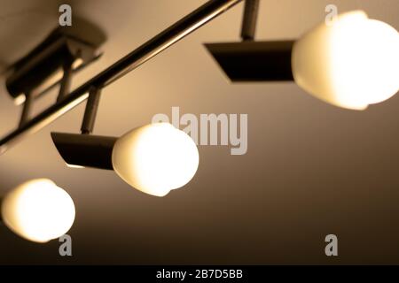 Some warm light bulbs mounted on a ceiling in a house - Electricity and illumination concept, Bucharest, Romania. Stock Photo