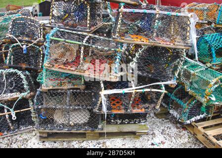 Lobster creels piled up in the harbour at St Abbs, Coldingham, Berwickshire, Scottish Borders, UK Stock Photo