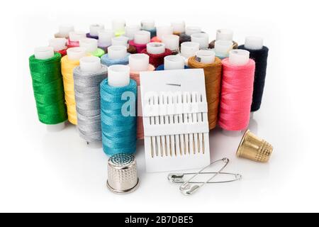 Tailor needles and threads over white. Stock Photo