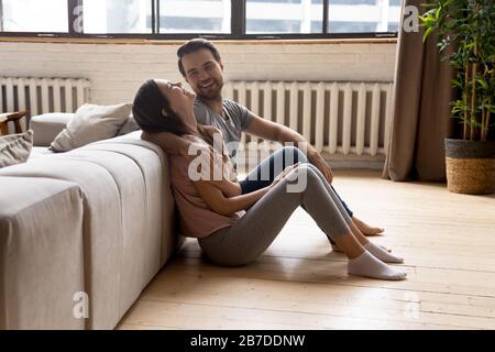 Happy young couple relax on warm wooden floor Stock Photo