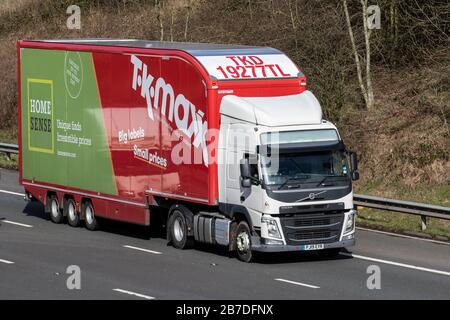 TK Maxx red white HGV Haulage delivery trucks, lorry, transportation, truck, cargo carrier, Volvo vehicle, European commercial transport industry, M61 at Manchester, UK Stock Photo