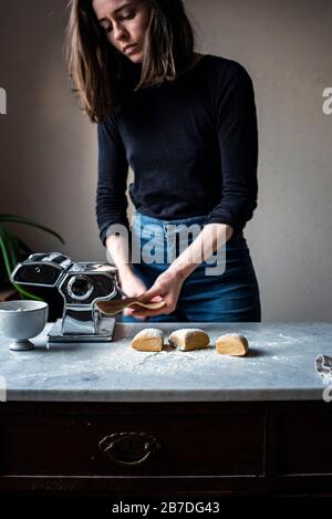 Woman Making Fresh Pasta in a kitchen Stock Photo