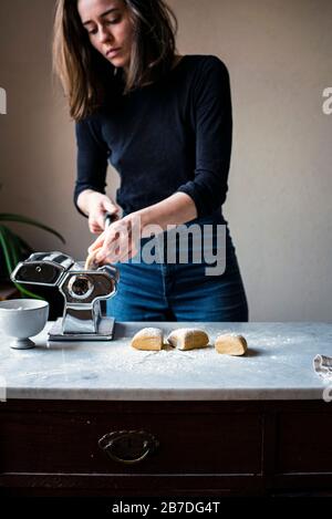 Woman Making Fresh Pasta in a kitchen Stock Photo