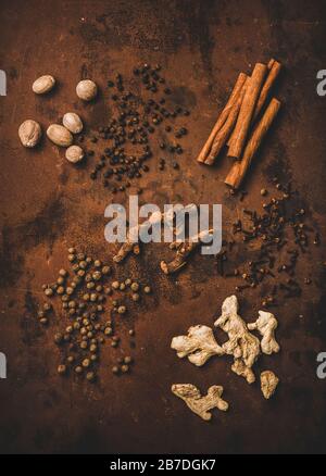 Turkish traditional seven spice Yedi Bahar mix for cooking. Flat-lay of black pepper, ginger, cloves, nutmeg, cinnamon, allspice and alpinia root over Stock Photo