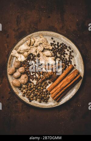 Turkish traditional seven spice Yedi Bahar mix for cooking. Flat-lay of black pepper, ginger, cloves, nutmeg, cinnamon, allspice and alpinia root in w Stock Photo