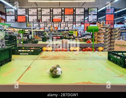 FULDA, GERMANY - MAR 14, 2020: Empty shelves for vegetables with single broccoli at Kaufland supermarket due to Coronavirus crisis. Panic buying leads Stock Photo