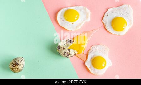 Three baked quail eggs on a pink green background. Pop art. Funny card Stock Photo