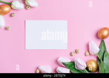 Greeting composition from freshly picked spring tulips flowers, handmade painted chicken and quail eggs, paper page on a pink background, copy cpace. Stock Photo