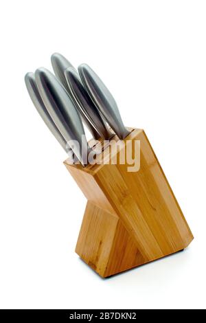Stainless steel knives in a light wood block on an isolated white background Stock Photo