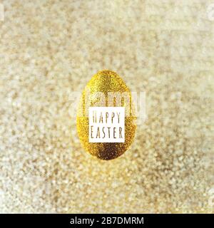 A golden egg hangs in the air. On a textured gold background. The concept on the theme of Easter. Stock Photo