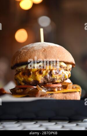 A burger on a plate, stacked in a burger bun Stock Photo