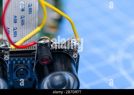 Close-ip of small camera and circuit-board with infrared light with cabled connected on a blue background. Stock Photo