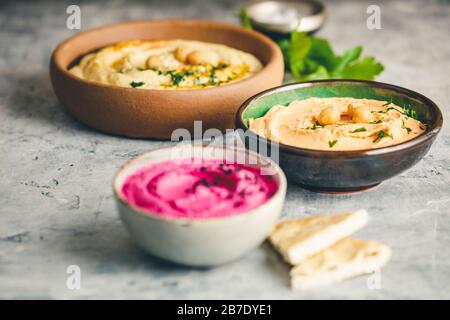 Various Vegetarian dips hummus. Different kinds of dips. Traditional hummus, herbs hummus, beetroot hummus and lentils humus Stock Photo