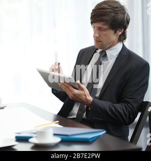 Business man with tablet pc working at office desk Stock Photo