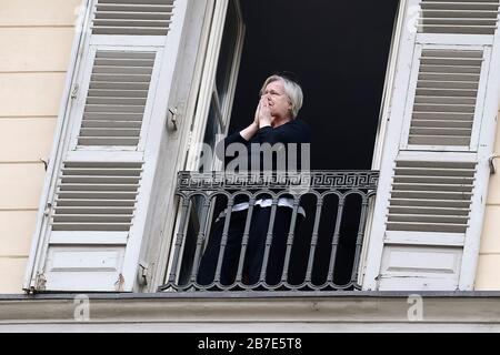 Turin, Italy. 15th Mar, 2020. TURIN, ITALY - March 15, 2020: A woman prays on a balcony. The Italian government imposed unprecedented restrictions to halt the spread of COVID-19 coronavirus outbreak, among other measures people movements are allowed only for work, for buying essential goods and for health reasons. (Photo by Nicolò Campo/Sipa USA) Credit: Sipa USA/Alamy Live News Stock Photo