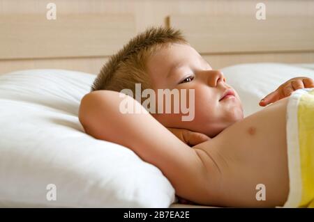 Cute little boy lying in bed before sleeping. Stock Photo