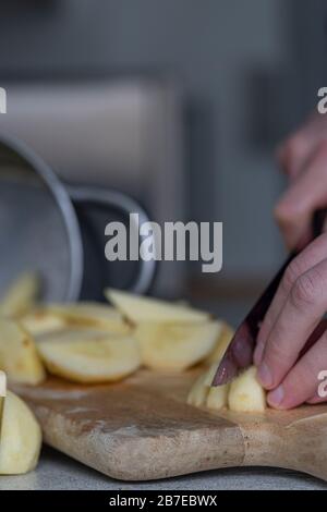 Peeling apples for apple pie hand visible. Stock Photo