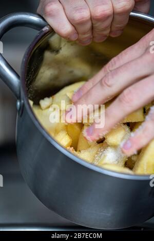 Peeling apples for apple pie hand visible. Stock Photo
