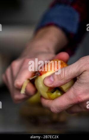 Peeling apples for apple pie hand visible. Stock Photo