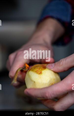 Peeling apples for apple pie hand visible. Stock Photo