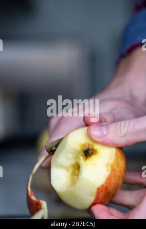 Peeling apples for apple pie hand visible. Stock Photo