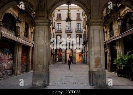 Barcelona, Catalonia, Spain. 15th March 2020. A woman walks through the empty streets of Barcelona. Spain’s state of alarm decree approved by the government on Saturday has immediately locked down the country, limiting the movement of citizens across the entire territory. Coronavirus deaths in Spain double in a day to reach 288, with more than 7,750 infections. Credit:Jordi Boixareu/Alamy Live News Stock Photo