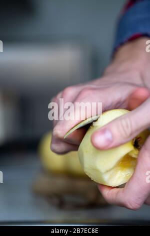 Peeling apples for apple pie hand visible. Stock Photo