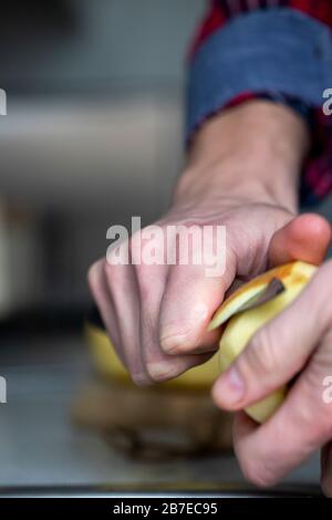 Peeling apples for apple pie hand visible. Stock Photo