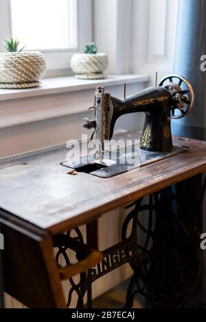 Budapest, Hungary - October 3, 2019: Vintage Singer sewing machine in front of the window - still life, home decor. Stock Photo