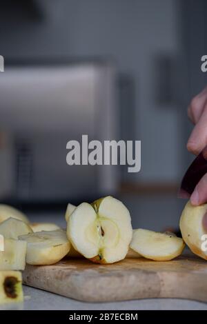 Peeling apples for apple pie hand visible. Stock Photo