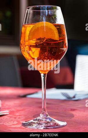 A glass with bright orange liquid, ice and a slice of orange, Spritz Aperol cocktail Stock Photo