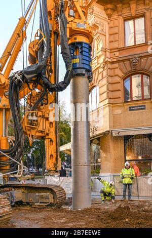 VIENNA, AUSTRIA - NOVEMBER 2019: Construction worker signalling to the driver of a drilling machine to position a boring tube on a site in Vienna Stock Photo