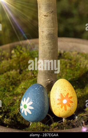 Beautiful shot of colorful Easter eggs with a flower pattern on the green grass on a sunny day Stock Photo