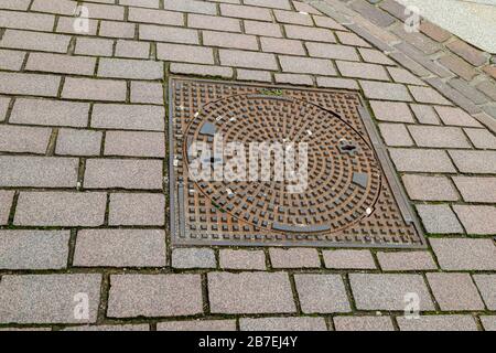 Iron manhole cover for the drainage of the road Stock Photo