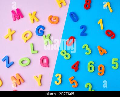 plastic multi-colored numbers and letters of the English alphabet on a blue-violet background, top view, back to school Stock Photo