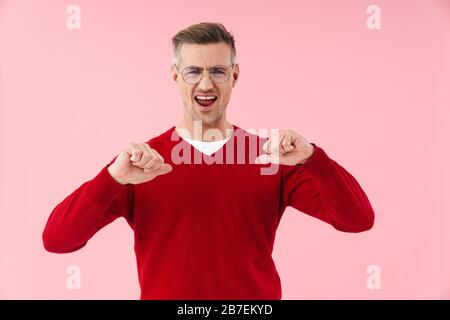 Portrait of handsome caucasian man wearing eyeglasses pointing fingers at himself isolated over pink background Stock Photo